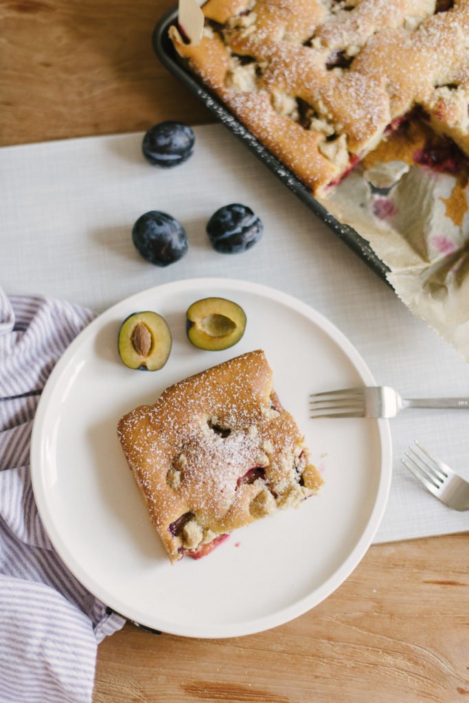 Ein Stück frischer Pflaumenkuchen mit Rührteig vom Blech.