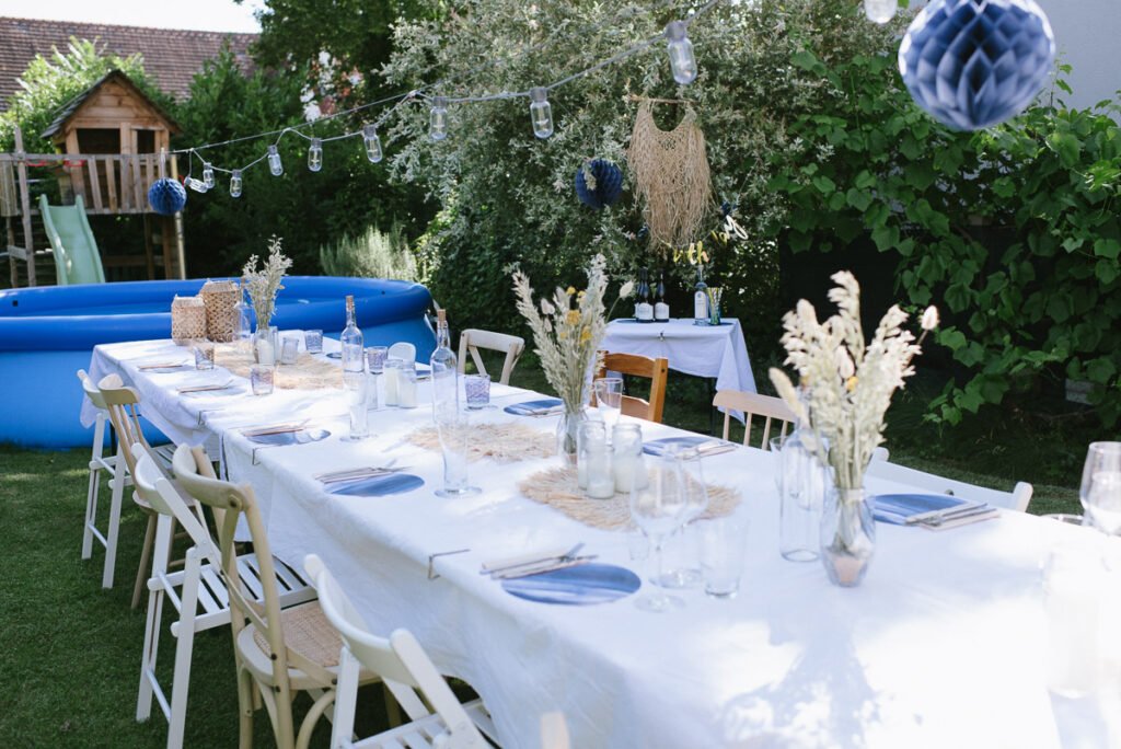 Lange Tafel im Garten mit Pool im Hintergrund