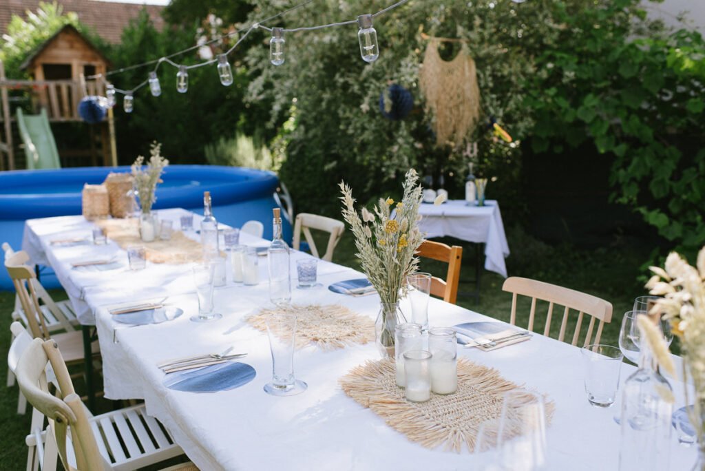 Gedeckte Tafel im Garten mit Pool im Hintergrund