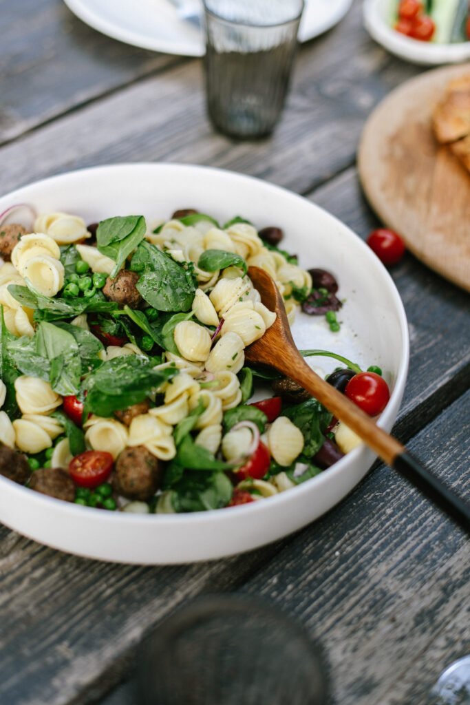 Lecker frischer Nudelsalat mit Spinat, Erbsen und Fleischbällchen