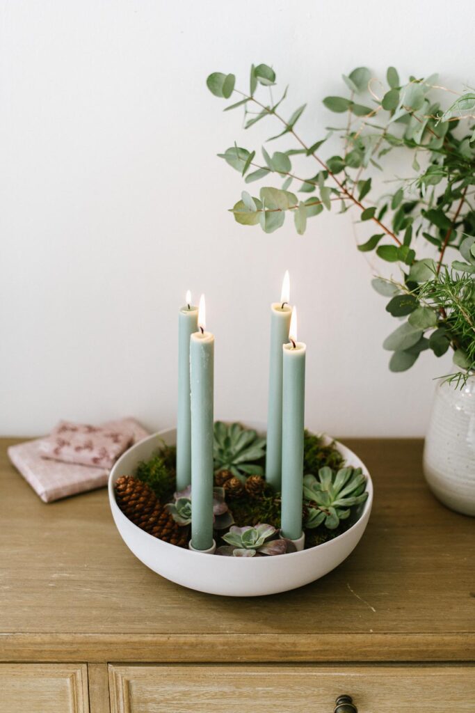 DIY Kerzenschale mit Sukkulenten als minimalistischen Adventskranz. Kerzenschale mit natürlichen Materialien füllen und Stabkerzen anzünden.