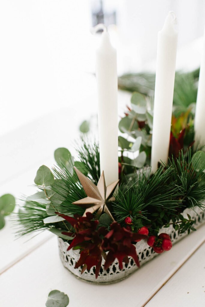 DIY Adventskranz mit Pflanzen für draußen weihnachtlich dekorieren mit grünen Zweigen und Beeren oder Olivenzweigen.