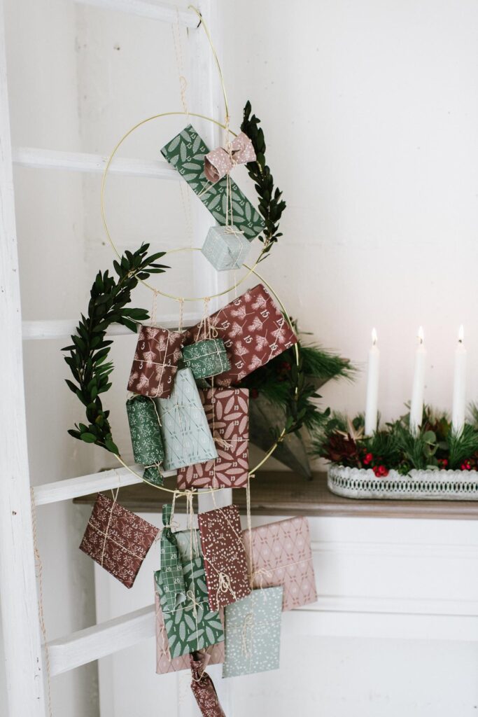 DIY Adventskranz mit Pflanzen für draußen weihnachtlich dekorieren mit grünen Zweigen und Beeren oder Olivenzweigen.