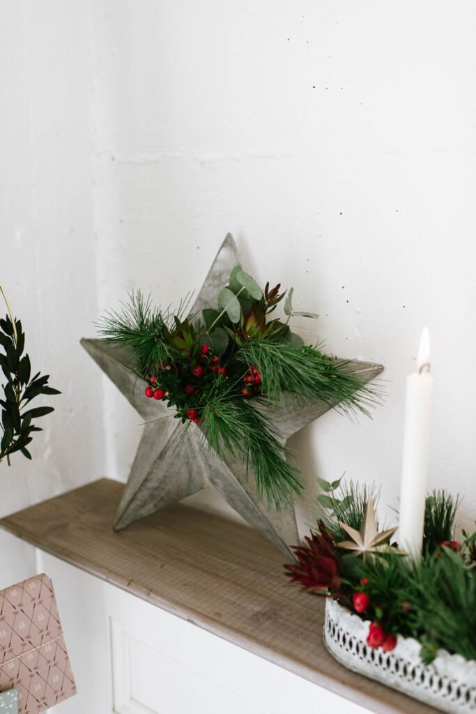 DIY Adventskranz mit Pflanzen für draußen weihnachtlich dekorieren mit grünen Zweigen und Beeren oder Olivenzweigen.