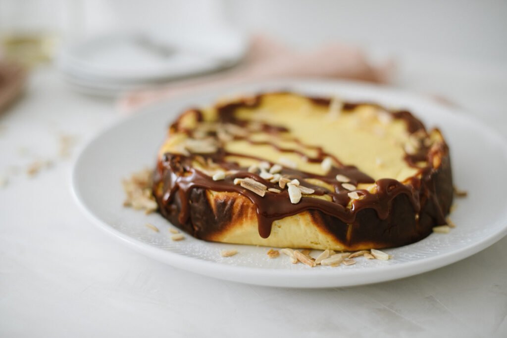 Einfacher Käsekuchen, ideal für Anfänger. Kleines Extra: Topping mit Karamellsauce und Mandelsplitter. Perfekt für den Sonntag, schnell gebacken.