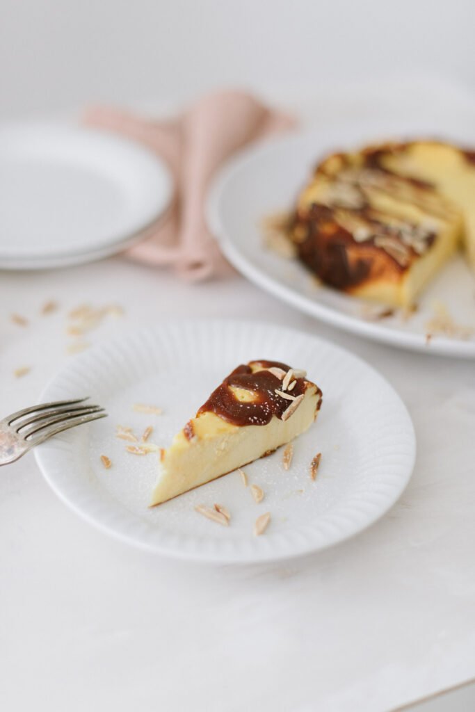 Einfacher Käsekuchen, ideal für Anfänger. Kleines Extra: Topping mit Karamellsauce und Mandelsplitter. Perfekt für den Sonntag, schnell gebacken.