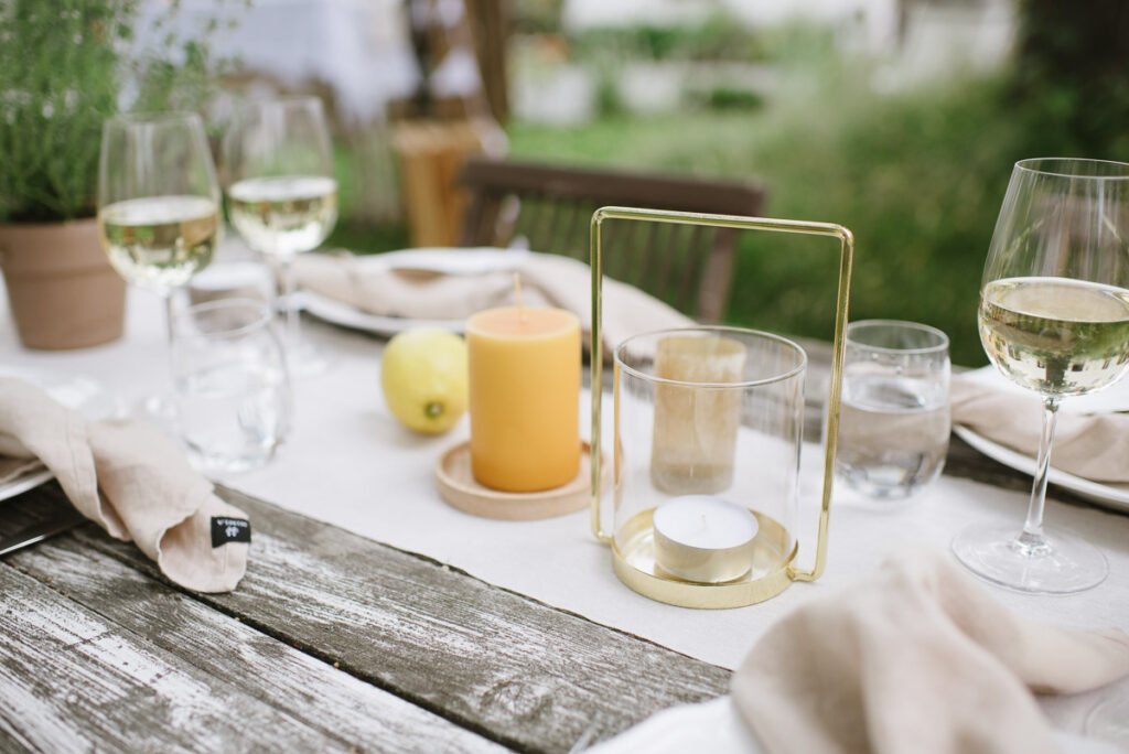 Gedeckter Tisch mit Laternen, Stumpenkerzen und Naturmaterialien