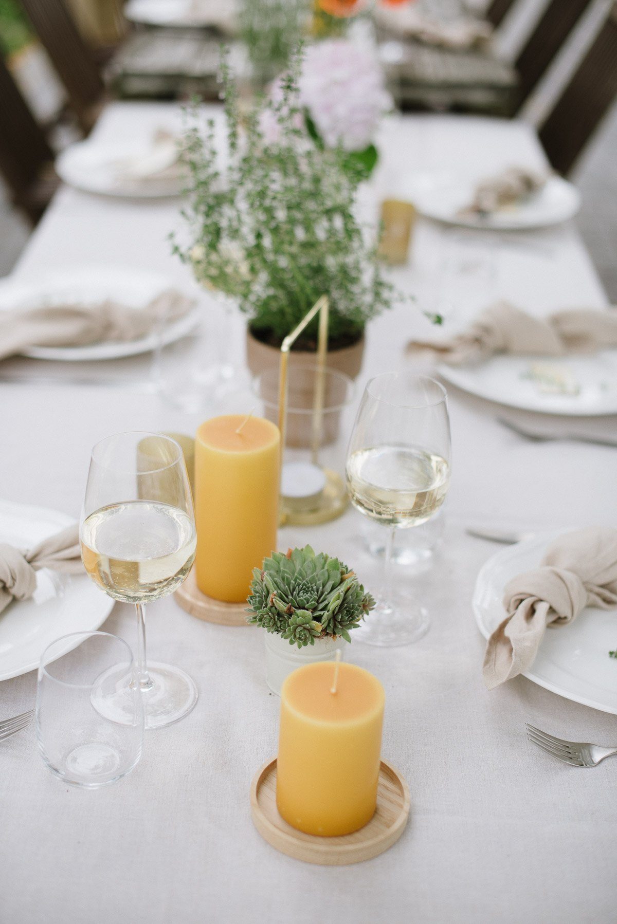 Gedeckter Tisch mit gelben Stumpenkerzen zu Gartenparty zum 40. Geburtstag