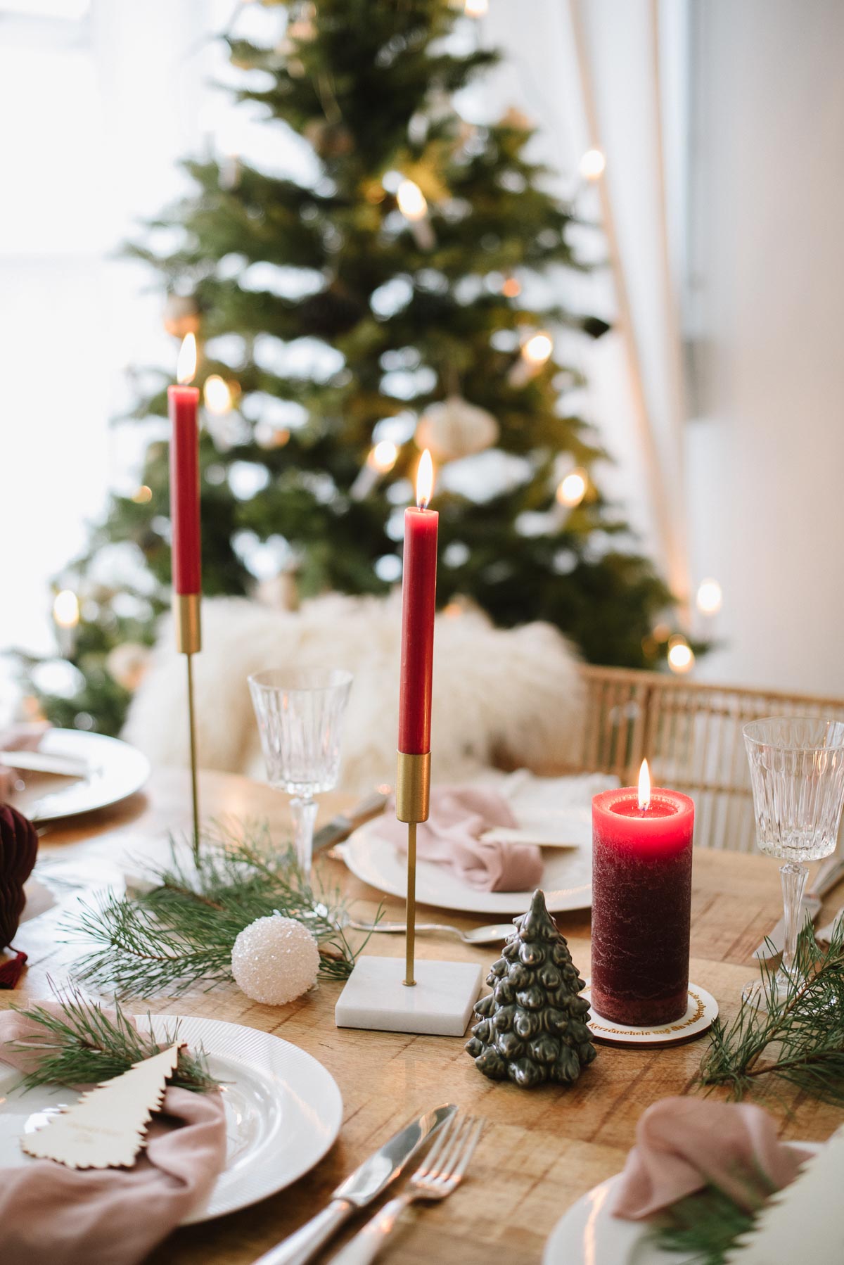 Gedeckter Tisch zu Weihnachten mit Stabkerzen in Bordeaux