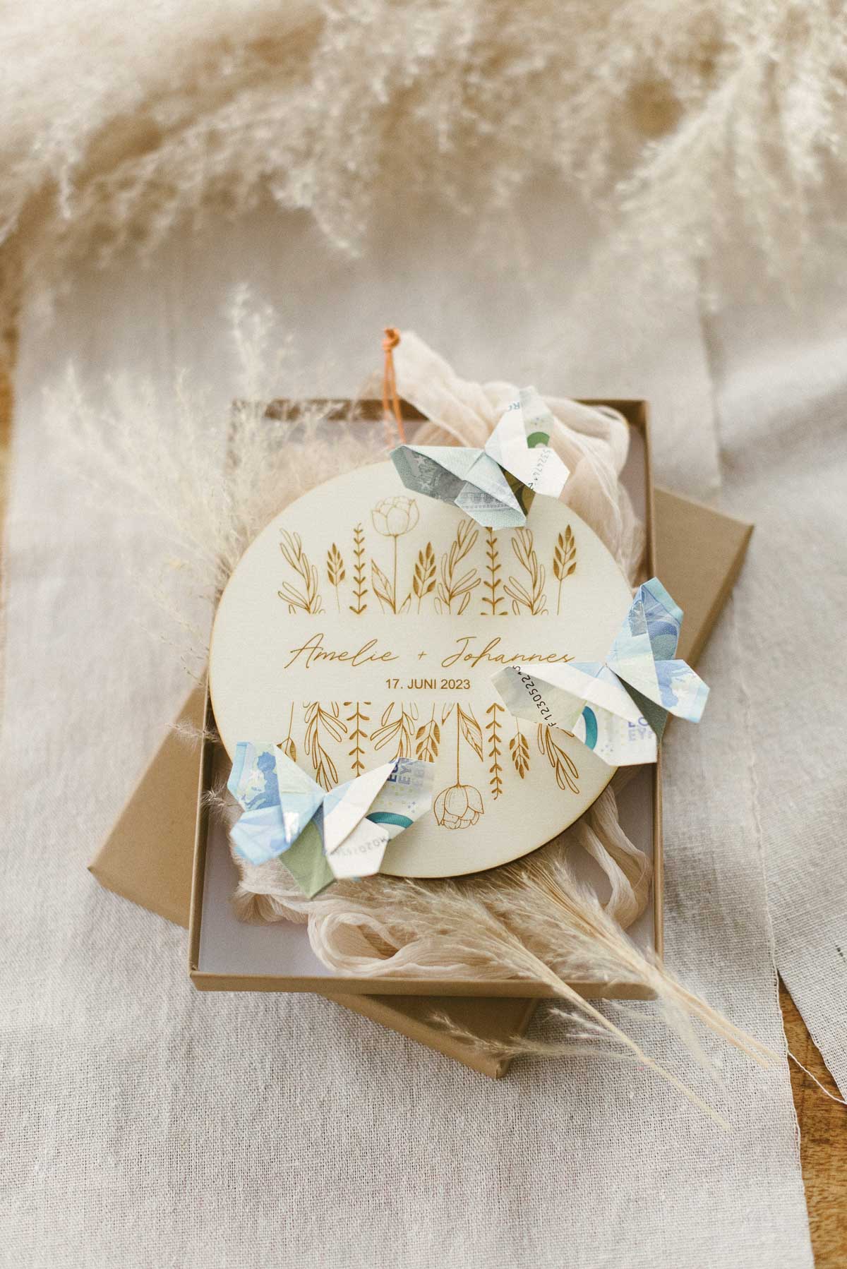 Geldgeschenk zur Hochzeit: Personalisierte Holzscheibe mit Geldscheinen als Schmetterlinge